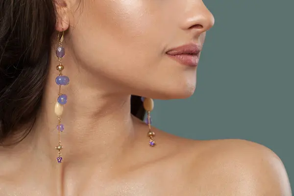 stock image Gold earring with blue and purple chalcedony stones on jewelry model closeup. 
