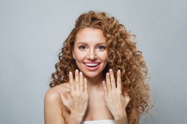 Şaşırtıcı derecede sağlıklı, doğal makyajlı, parlak ve uzun kıvırcık saçlı bir model. Saç bakımı, cilt bakımı, kozmetoloji ve stil konsepti