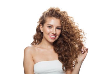 Kıvırcık saçlı, doğal makyajlı ve beyaz arka planda poz veren güzel bir manken. Cilt bakımı, saç bakımı ve kozmetik konsepti