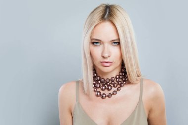 Kadın yüzünün mücevher portresi. Beyaz arka planda genç sarışın kadın