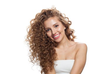 Doğal makyajlı, taze tenli ve beyaz arka planda dalgalı saçlı arkadaş canlısı genç bir kadın.