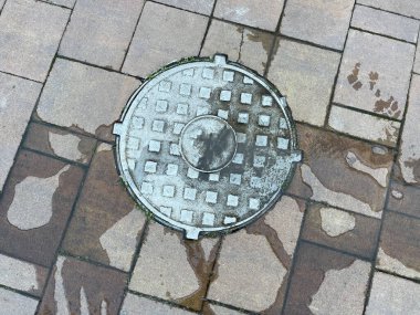 Su ve kanalizasyon kazası. Kanalizasyonu yarıp geçme sistemi. Su kanalizasyon kapağından şehir caddesine akıyor.