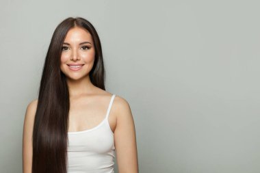 Esmer, doğal makyajlı, sağlıklı ciltli ve uzun saçlı bir kadın. Kadın güzelliği, kozmetoloji ve cilt bakımı