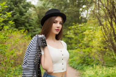 Açık havada genç bir bayan. Temiz tenli, siyah şapkalı, uzun kahverengi saçlı sağlıklı bir kadın. Seyahat, tatil, sezon ve tatil konsepti