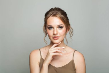 Doğal makyajı, sağlıklı cildi, güzel saç stili, moda stüdyosu portresi olan güzel, modaya uygun bir kadın.