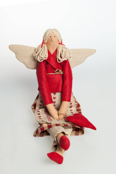 Белье куклы сидя на сером фоне, игрушки или украшения интерьера 