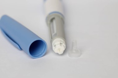 Kendi kendine enjeksiyon kalemi, tip 2 diyabet tedavisinde kullanılan antidiyabetik ilaçlar ve anti-obezite ilaçları. Beyaz arkaplan üzerinde yarımatid makro
