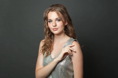 Makyajlı, uzun dalgalı saçlı, yakın plan portresi olan çekici bir genç bayan. Güzel kadın.