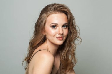 Makyajlı, uzun dalgalı saçlı, yakın plan portresi olan güzel bir bayan. Güzel kadın.