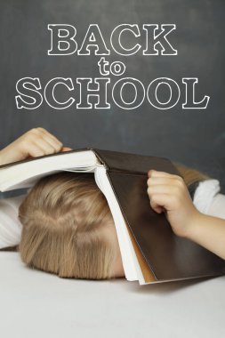 Sınıfta beyazlara karşı ders kitabının altında saklanan küçük bir kız öğrenci. Okula geri dönüp tahtaya yazı yazmış.