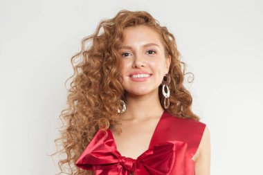 Taze tenli ve beyaz arka planda izole edilmiş dalgalı, uzun, sağlıklı saç stiline sahip güzel, genç bir kadın.