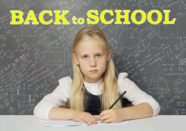 Sınıftaki üzgün kız öğrenci beyaza karşı okula geri döndü tahtaya yazı yazıldı