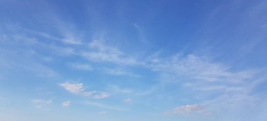 Mavi gökyüzünde beyaz bulutlar, rüzgarlı bahar arkaplanı