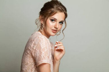 Taze tenli hoş, zarif bir kadın, beyaz arka planda updo saçlı ve makyajlı. Güzel yüz yakın plan