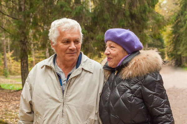 Влюбленная старшая пара на прогулке в осеннем парке