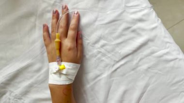 Hastaneye kaldırılırken salin alırken yaşlı çocuğun ellerini kapatın..