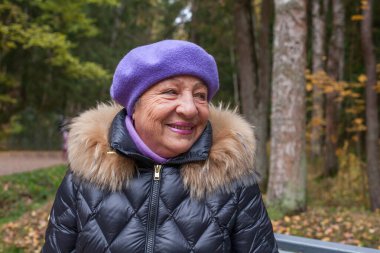 Mavi şapkalı mutlu yaşlı kadın portresi.