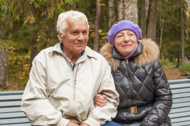 Gülümseyen adam ve kadın sonbahar parkında son sınıf çifti
