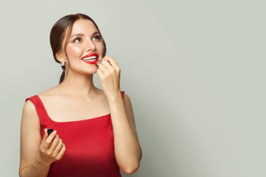 Kırmızı ruj süren neşeli esmer kadın güzelliği ve zarafeti vurguluyor..