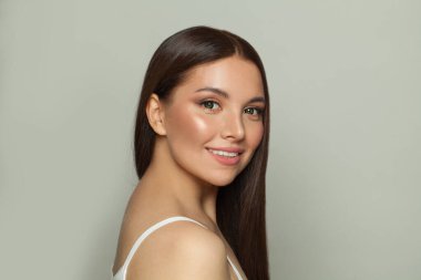 Parlak tenli neşeli esmer kadın, zarif makyaj ve nazik bir gülümseme. Genç model poz, portre