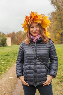 Sonbahar arka planında sarı yapraklı güzel bir kadın, portre.