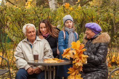 Sonbaharda parktaki neşeli aile neslinin açık hava portresi.