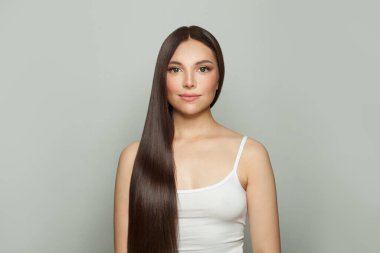 Parlak, uzun, kahverengi saçlı, görkemli model kadın. Kozmetik, saç ve cilt bakımı, keratin tedavisi ve spa konsepti