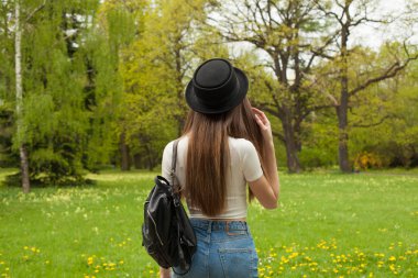 Çekici gezgin kadın bahar parkında geziyor.