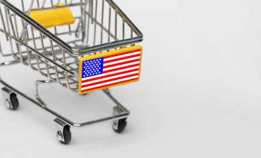 Alışveriş, KDV ve ABD konseptinde perakende satış. Beyaz arka planda Amerikan bayrağı olan alışveriş arabası.