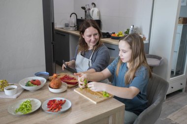 Anne ve kızı mutfakta lezzetli yemekler hazırlıyorlar..