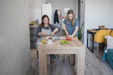 Mutlu sevgi dolu aile birlikte yemek hazırlıyor. Ev yapımı yemek ve küçük bir yardımcı..