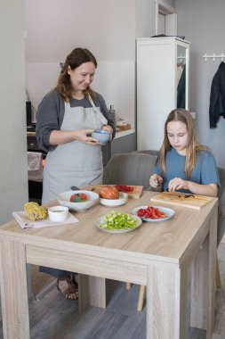 mutlu anne ve kızı bir salata yemek.
