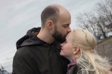 Uzun sarı saçlı tatlı bir kadın ve deniz kenarında öpüşen bir çift..