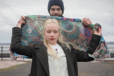 Sarışın ve dışarıda yakışıklı bir erkek olan hoş bir genç bayan. Mutlu çift.