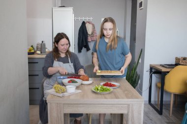 Sevgili kızı ve annesi birlikte ev mutfağında yemek pişiriyorlar, aile portresi yapıyorlar..