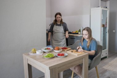 Sevimli kız mutfakta yemek hazırlıyor..