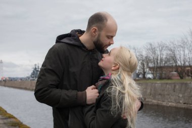 Sarı saçlı kaygısız genç kadın ve açık havada yakışıklı bir adam. Mutlu çift.