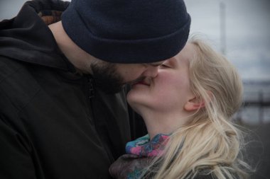 Öpüşen çift. Sarışın genç bir kadın ve yakışıklı bir adam..