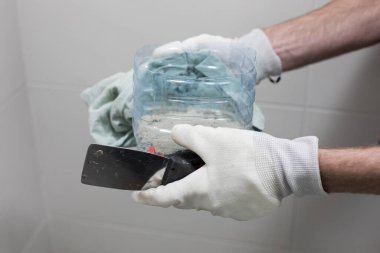 Banyo yenileme işleri için mala ve çimento yapıştırıcısı erkeklerin elinde. Kapatın..