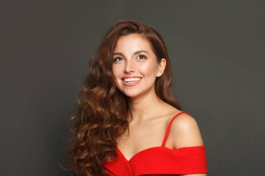 Siyah arka planda uzun saçlı ve makyajlı hoş bir kadın. Kıvırcık saçlı, güzel bir kadın.