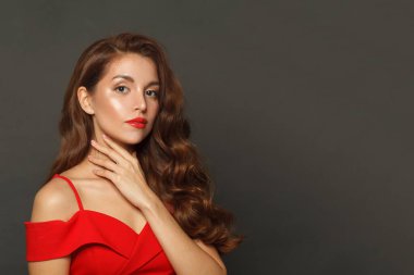 Siyah arka planda uzun saçlı ve makyajlı güzel bir kadın. Kıvırcık saçlı, güzel bir kadın.