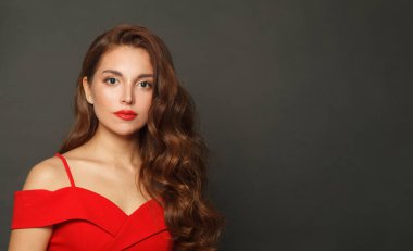 Uzun saçlı ve siyah makyajlı başarılı bir kadın. Kıvırcık saçlı, güzel bir kadın.