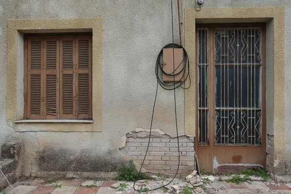 放棄された家の玄関口 古いドアの崩壊壁と窓のシャッター — ストック写真