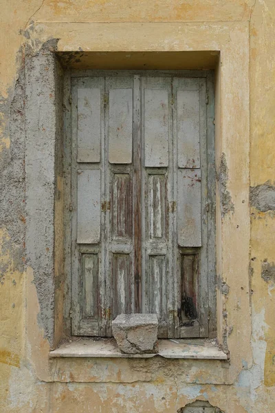 废弃房屋的带有木制百叶窗和风化墙壁的旧窗户 — 图库照片