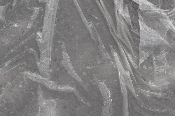 透明的塑料布 在冰水的水坑里有褶皱和折痕 摘要背景覆盖 — 图库照片