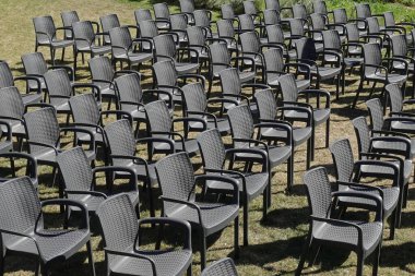 Sıralar dolusu siyah plastik sandalye. Bahçedeki mobilyalar.