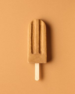 Kahverengi arka planda karamel fıstıklı dondurma.