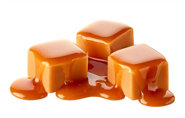 Три сладких карамельных конфеты кубики увенчанные карамельным соусом изолированы на белом фоне
