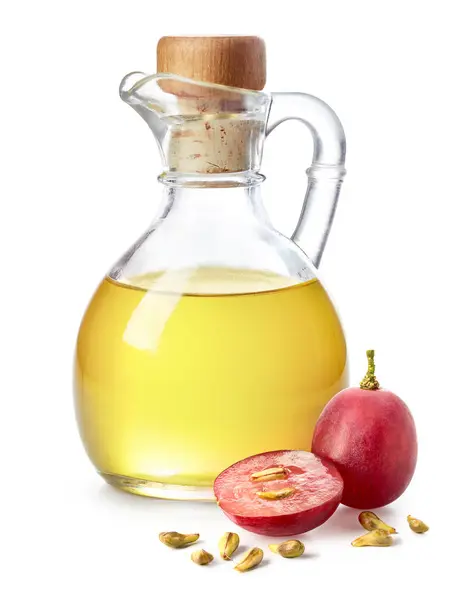 一盒葡萄籽油和新鲜成熟的红色葡萄 种子在白色背景上分离 免版税图库图片