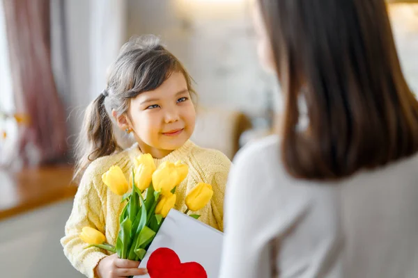 母亲节快乐 小女儿向妈妈道贺 并送给她一束鲜花 — 图库照片